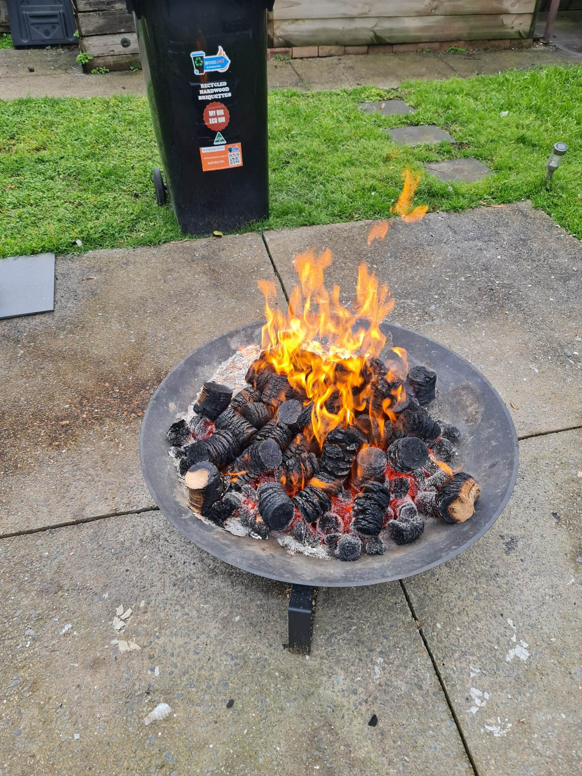 Fire pit with firewood briquettes burning brightly
