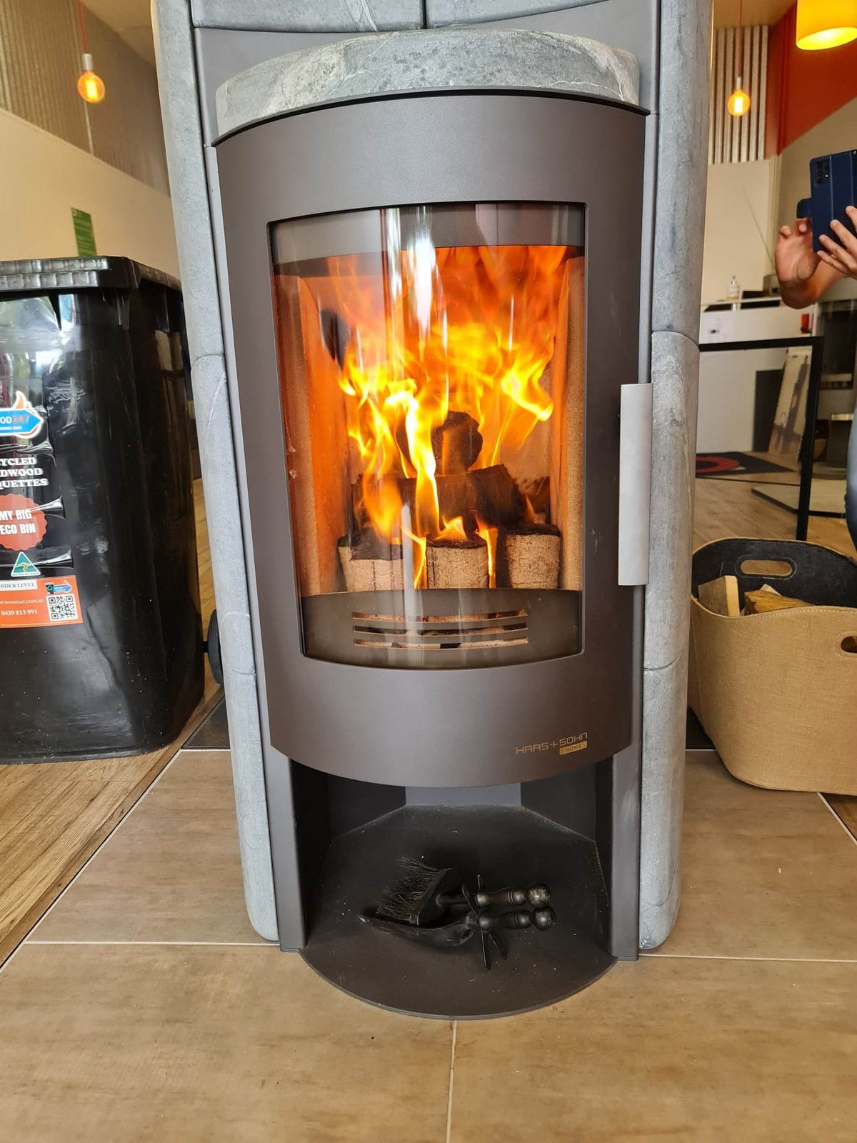 Freestanding wood heater with a bright fire behind the glass